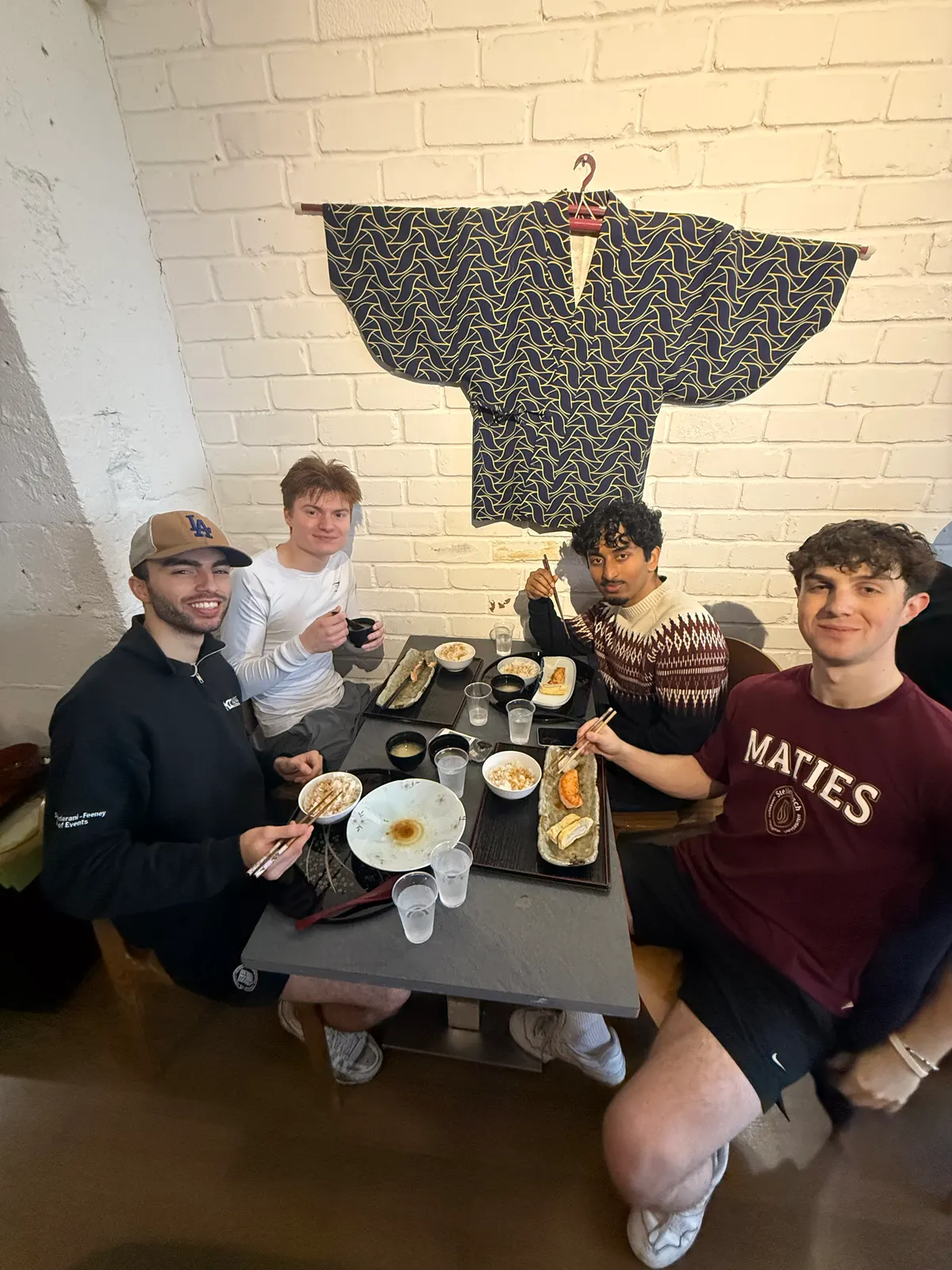 Five people at a table with bowls of food