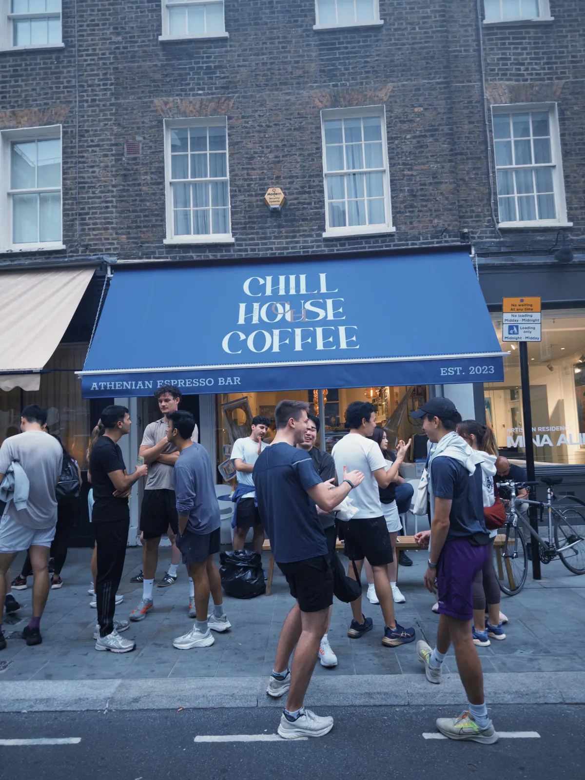 Runners standing about in the street outside the cafe